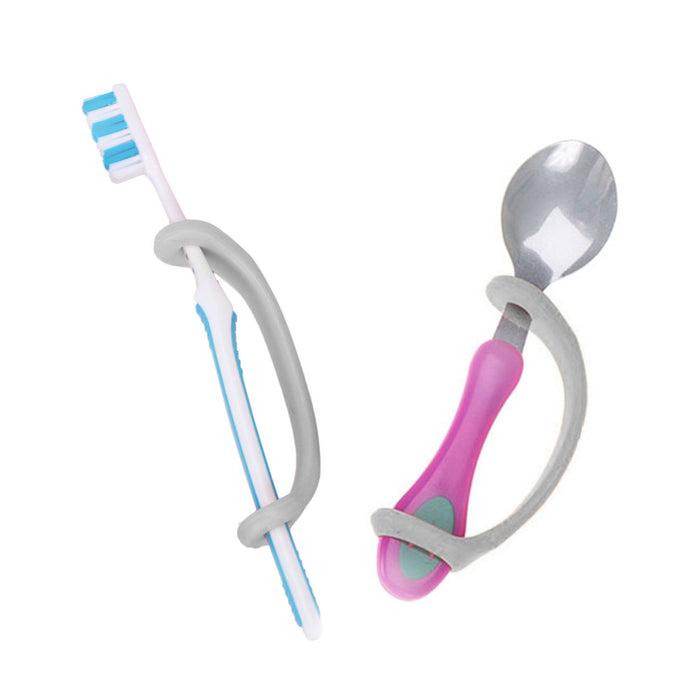Set of toothbrush and spoon held with a silver EaZyHold Grip Aid on a white background