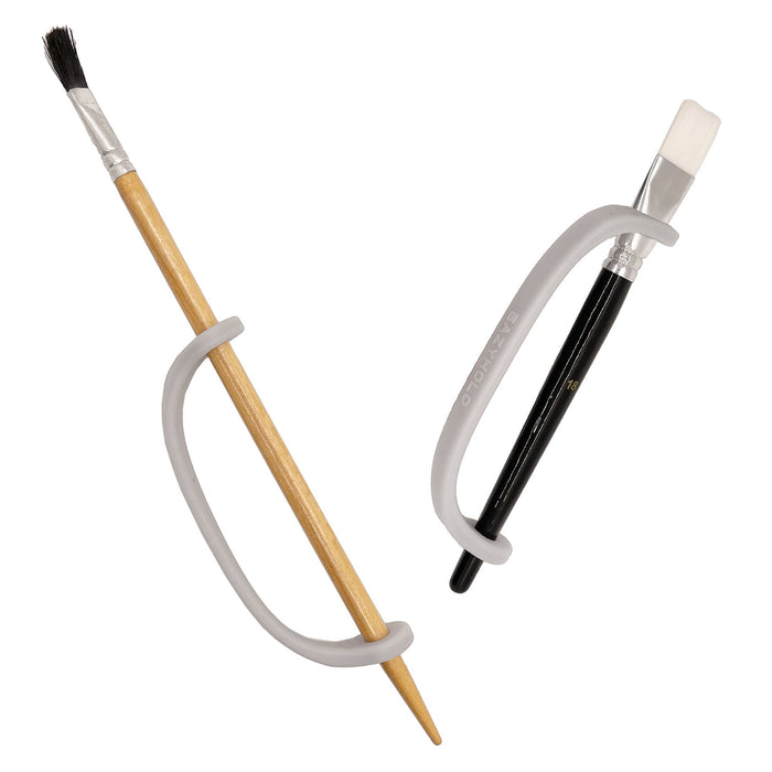 Two paintbrushes with different handles and bristle heads with a silver EaZy Hold Grip Aid on a white background
