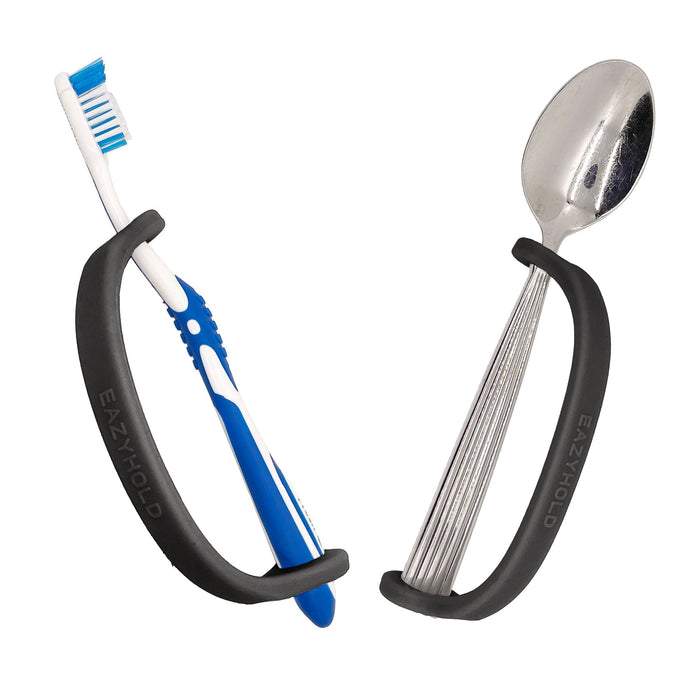 Silver spoon and toother brush with a black EaZy Hold Grip Aid on a white background