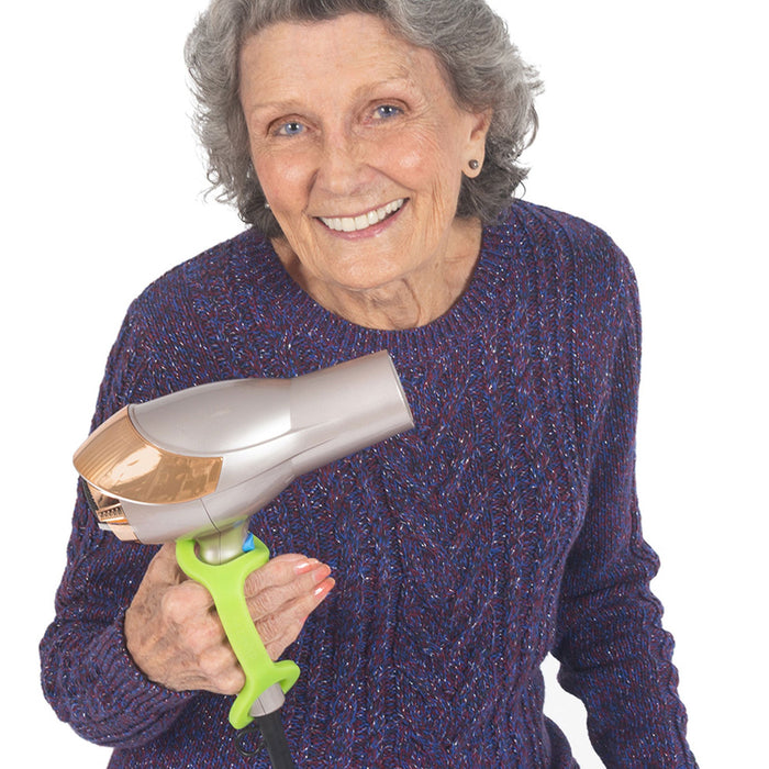 Woman holding a hair dryer with a lime green EaZyHold Grip Aid on a white background