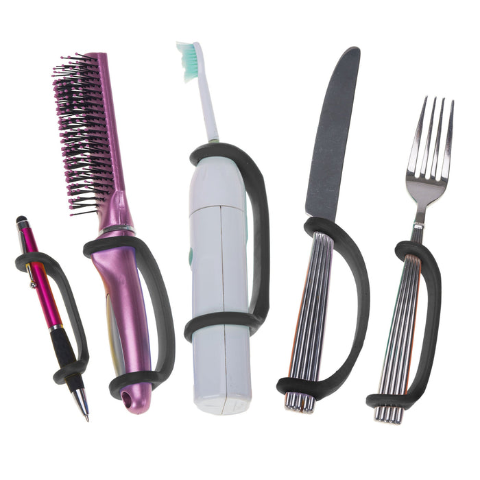 Set of tools including a hairbrush, toothbrush, knife, and fork with a black EaZyHold Grip Aid on a white background