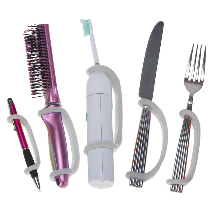 Set of tools including a hairbrush, toothbrush, knife, and fork with a platinum EaZyHold Grip Aid on a white background