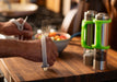 Person holding a fork with an EaZy Hold Grip Aid on a kitchen counter with pepper and salt shakers