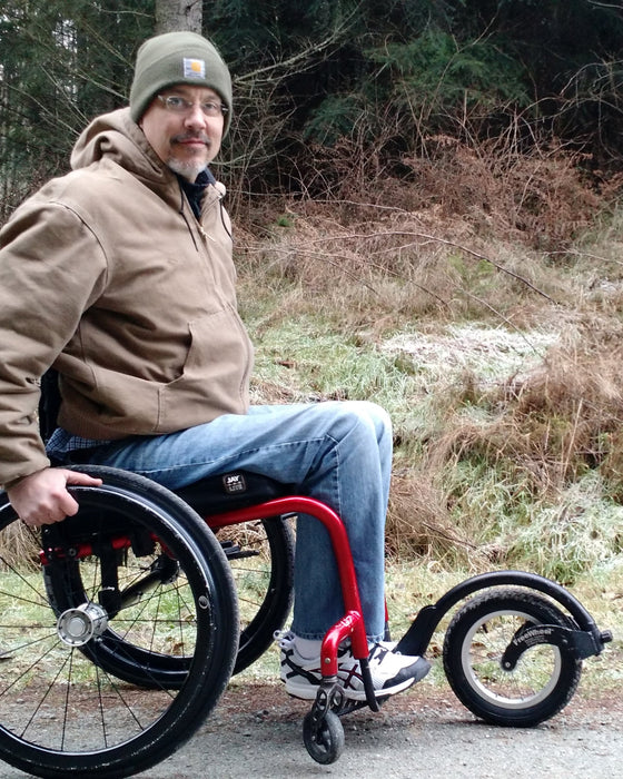 FreeWheel Wheelchair Attachment user in the woods.