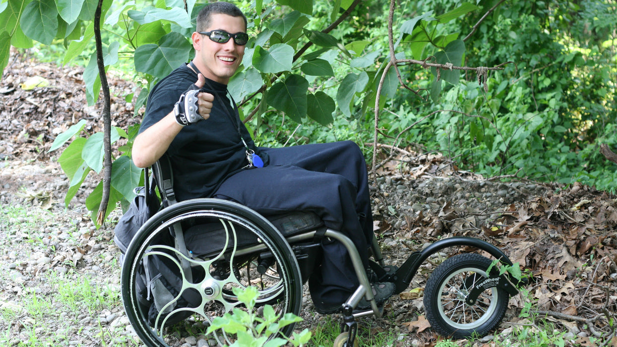 FreeWheel Wheelchair Attachment user in the woods.