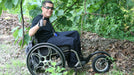 FreeWheel Wheelchair Attachment user in the woods.