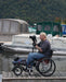 FreeWheel Wheelchair Attachment user using a camera on a tripod.