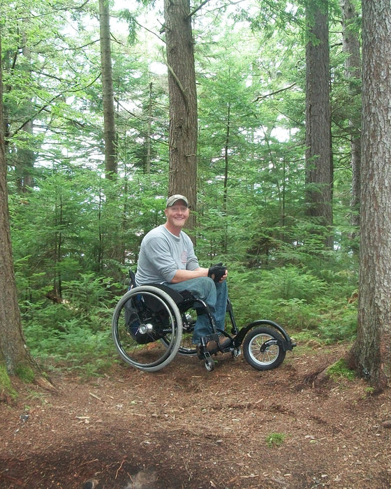 FreeWheel Wheelchair Attachment user in the woods.