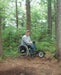 FreeWheel Wheelchair Attachment user in the woods.