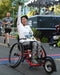 FreeWheel Wheelchair Attachment user crossing the finish line in a half marathon.