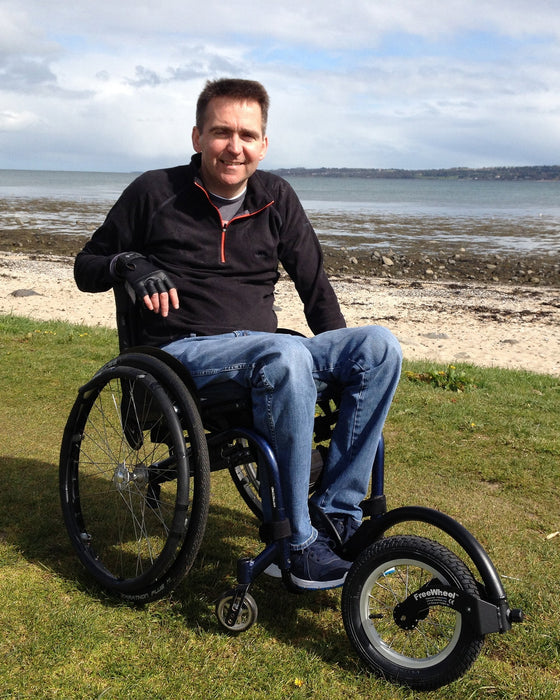 Potrait of a FreeWheel Wheelchair Attachment user picking blueberries.