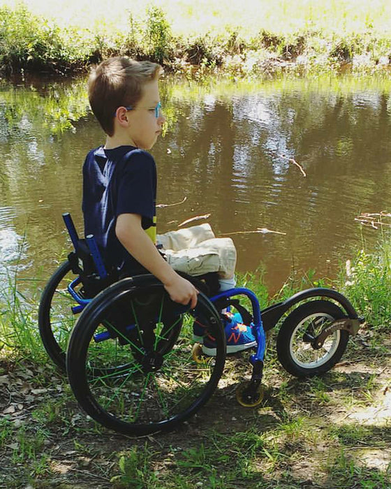 FreeWheel Wheelchair Attachment kid user along the water.