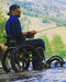 FreeWheel Wheelchair Attachment user fishing in the water with their dog.