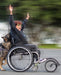FreeWheel Wheelchair Attachment user being pushed by their service dog.