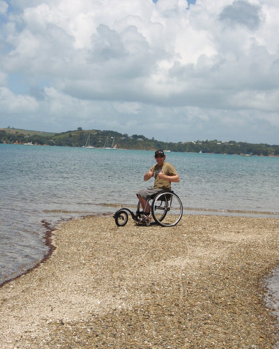 FreeWheel Wheelchair Attachment user on the beach.