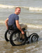 FreeWheel Wheelchair Attachment user in the water at a beach.