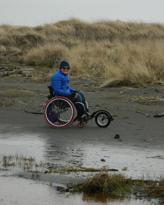 FreeWheel Wheelchair Attachment user on the beach.