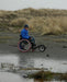 FreeWheel Wheelchair Attachment user on the beach.