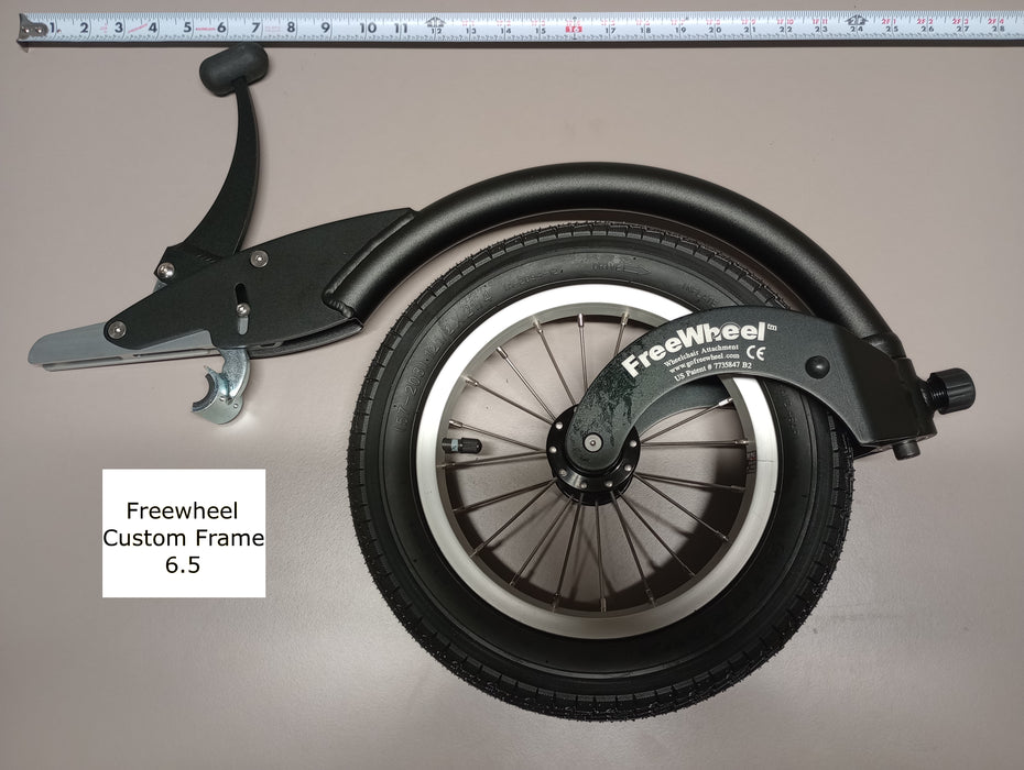 FreeWheel Wheelchair Attachment Black Size 6.5" against a tape measure.