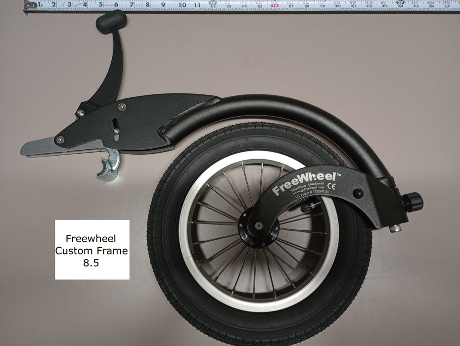 FreeWheel Wheelchair Attachment Black Size 8.5" against a tape measure.