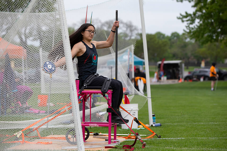Athlete throwing discus from an elevated chair at the Great Lakes Games.