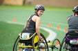 GLASA wheelchair racing athlete smiling on the racetrack while looking back at the camera.