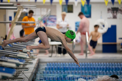 Swimmers diving to start a race at the Great Lakes Games.