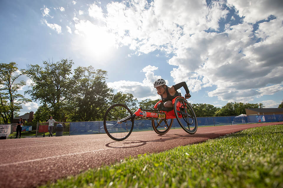 Athlete racing in wheelchair track event at the Great Lakes Games.