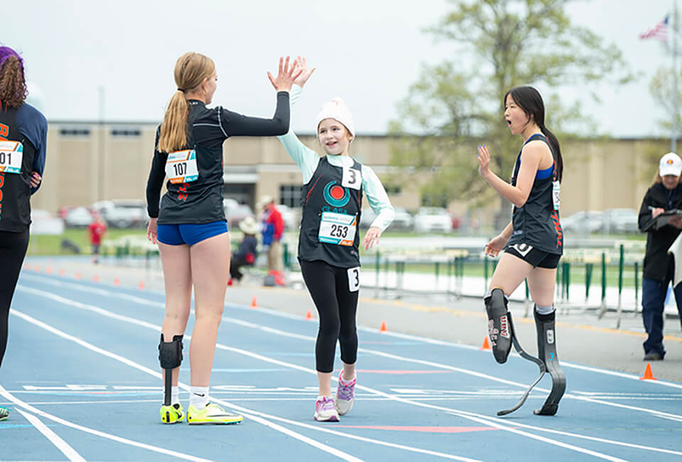 Group of athletes congratulating after a  race in a track event at the Great Lakes Games.