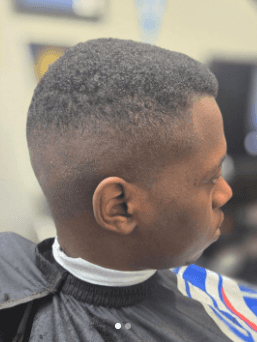 Person with a styled haircut in a barbershop setting