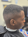 Person with a styled haircut in a barbershop setting