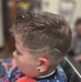 Child with a styled haircut in a barbershop setting