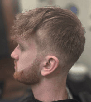 Man with a styled haircut and beard in a barbershop setting