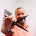 Team Amplife® Ambassador Travis Sanders holding a pair of blue scissors with a blurred background