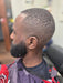 Man with a styled haircut and beard in a barbershop setting