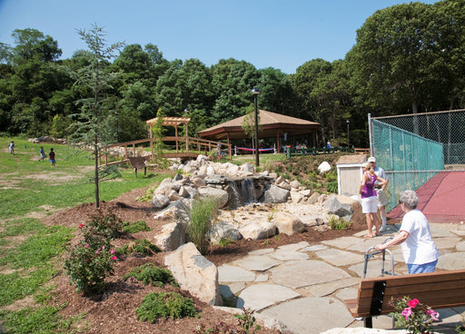 Community park with playground, gazebo, and people enjoying the outdoors