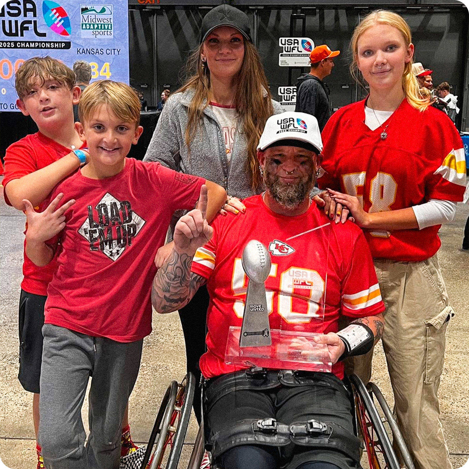 Group portrait of Jason Loftiss and his family at the 2025 USA Wheelchair Football League Championships, as he holds the championship trophy