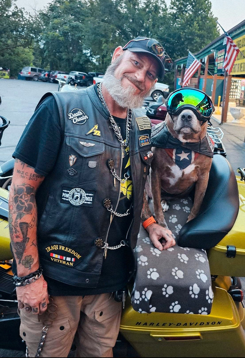  standing next a motorcycle with a dog in a motorcycle seat cover