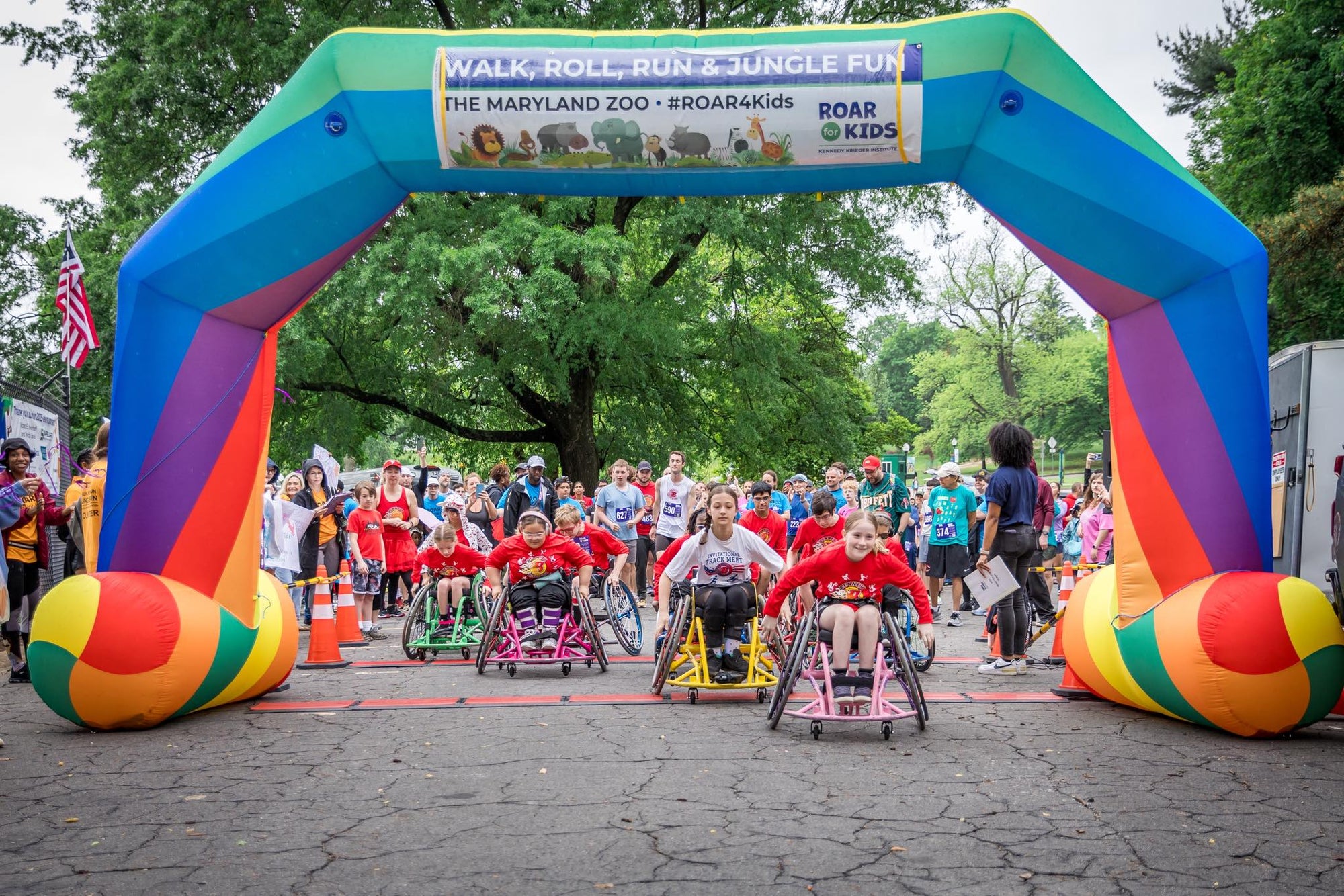 Colorful inflatable archway at a race event for Kennedy Krieger Institute with participants and spectators.