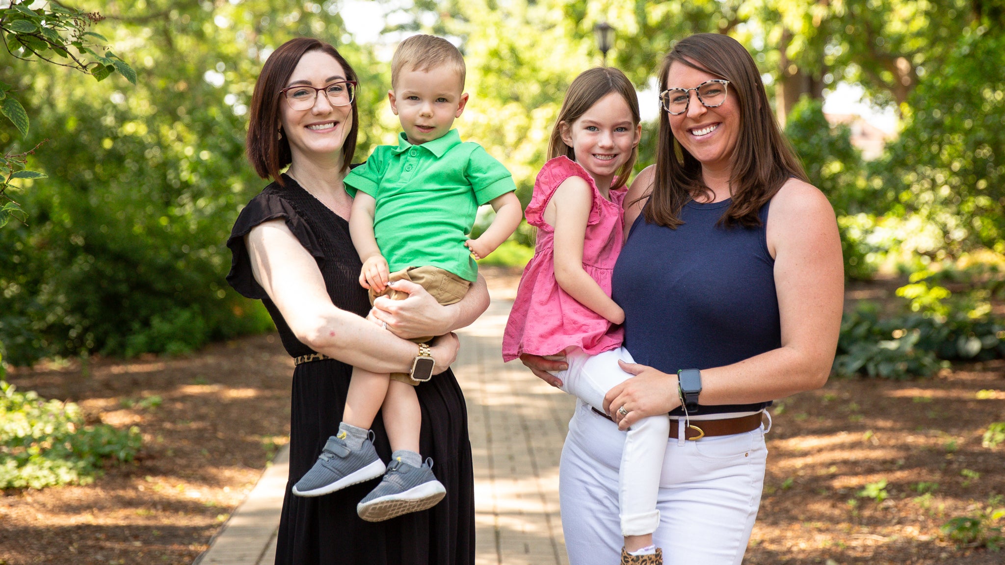 Group portrait of Ali Barnum, Kari Treat and their kids in a garden.