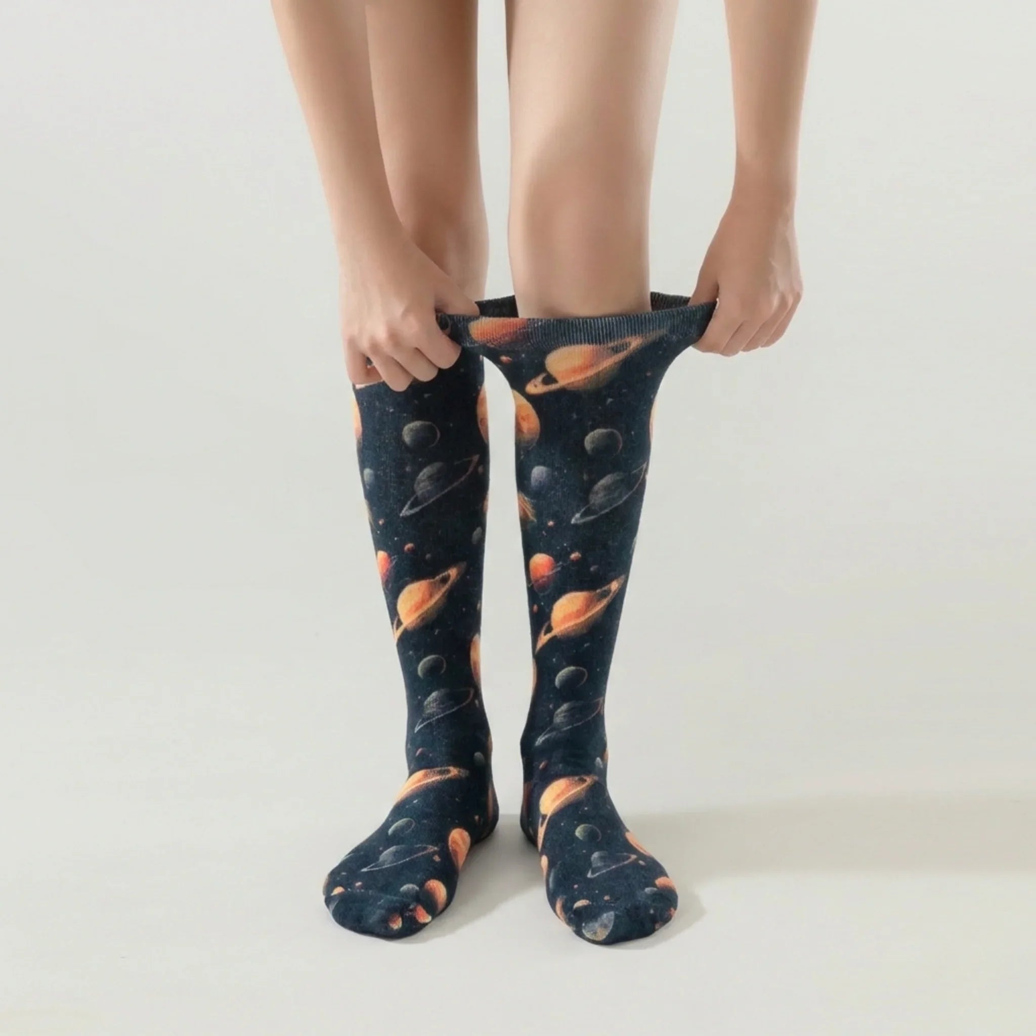 Lairos Deep Galaxy Kids' AFO Socks worn on model as they stretch the collar on a white background