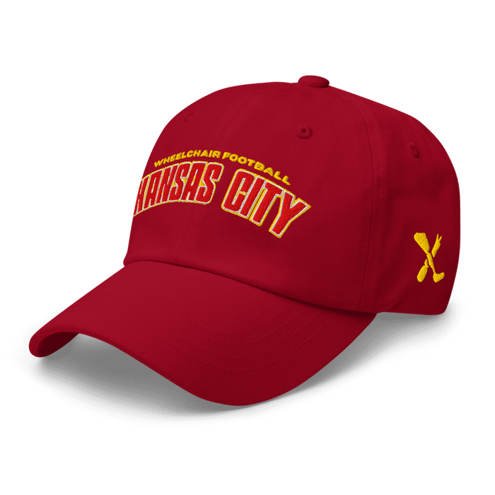 Front left angle of the MAS Kansas City Wheelchair Football Arch Cranberry Dad Hat against a white background