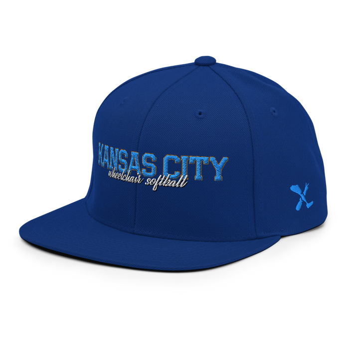 Front left angle of the MAS Kansas City Wheelchair Softball Script Royal Blue Flat Bill Snapback against a white background