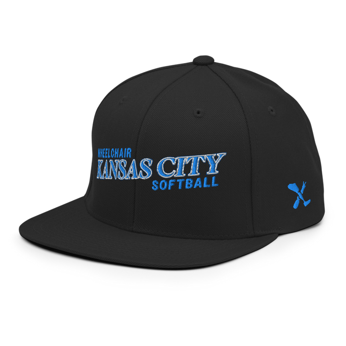 Front left angle of the MAS Kansas City Wheelchair Softball Slant Black Flat Bill Snapback against a white background