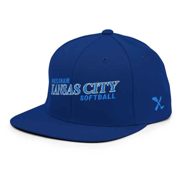 Front left angle of the MAS Kansas City Wheelchair Softball Slant Royal Blue Flat Bill Snapback against a white background