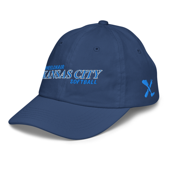 Front left angle of the MAS Kansas City Wheelchair Softball Slant Royal Youth Dad Hat against a white background