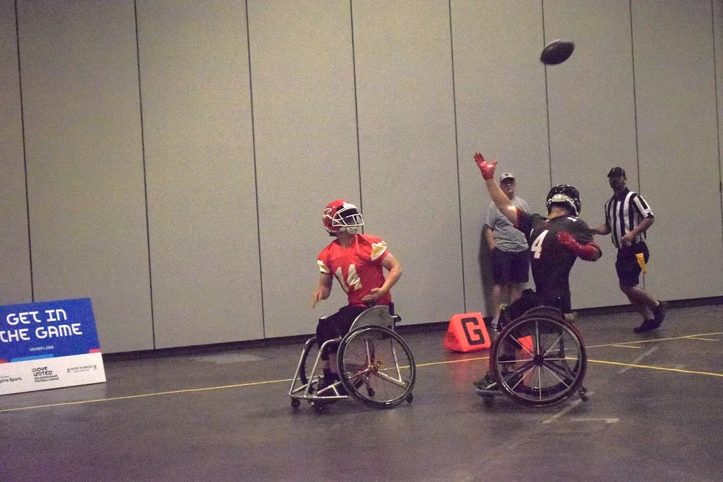 MAS Kansas City Chief's receiver looks back to catch ball over shoulder while defender tries to bat away pass
