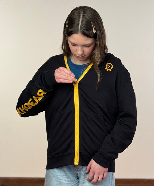 Person wearing the MagZip Adaptive Lightweight Hoodie with Magnetic Zipper while zipping up with one hand on a white background