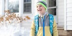 Child wearing a colorful winter outfit in front of a house. The jacket features a MagZip Magnetic Zipper Top Stopped Round Base #5