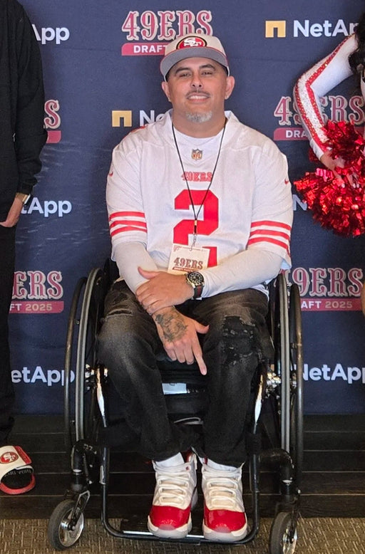 Man in a wheelchair wearing a San Francisco 49ers jersey.